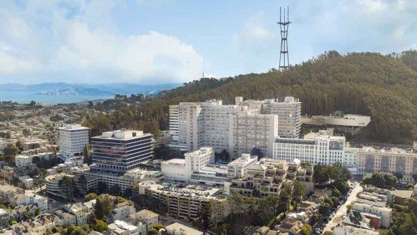 An aerial view of the Parnassus Heights campus and Mount Sutro among a cloudy sky.