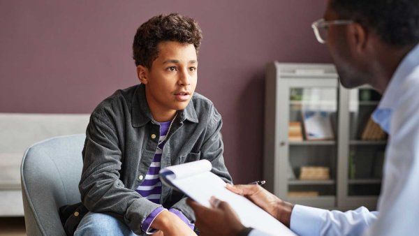 A young pre-adolescent boy speaks with a psychologist.