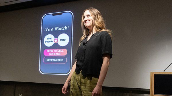 UCSF PhD student Sophia Miliotis presenting in front of a screen that looks like a dating app and reads "It's a Match: viral peptide or MHC." Buttons below read "send to cell surface" and "keep swiping."