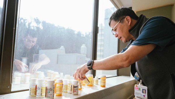 A pharmacist shows the many medications that kidney transplant patients need to take on a daily basis.