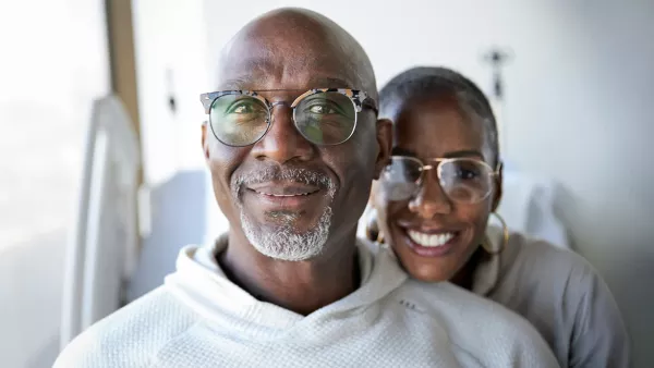 Forty-niners coach Johnny Holland and his wife smile together in a hospital room.