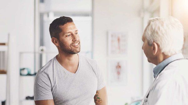 A young male patient has a discussion with a doctor.
