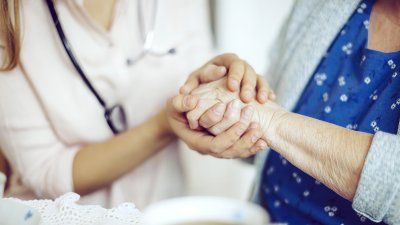 elderly_woman_holding_hands_doctor.jpg
