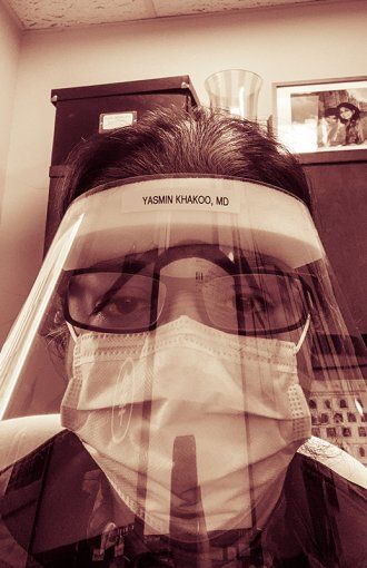 Portrait of Yasamin Khakoo in a face shield and surgical mask.
