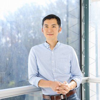 Tien Peng, MD, assistant professor in Medicine and recent recipient of the NIH New Innovator Award, standing before a large window