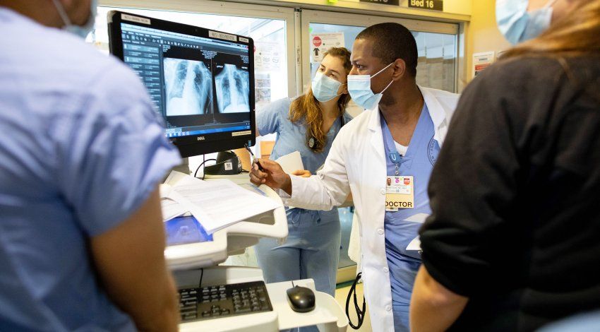 medical staff look at a respiratory image on a screen in the ICU 