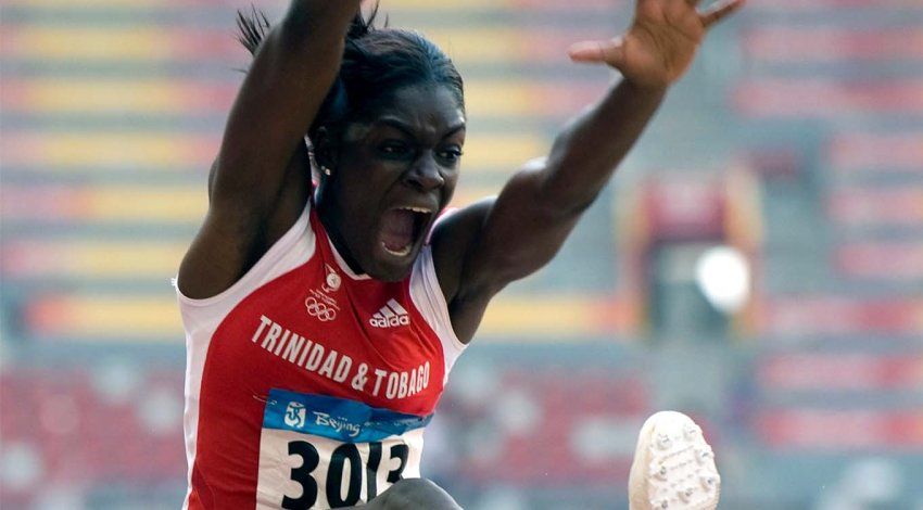 Photo of Rhonda Watkins flying through the air when competing in a long jump.
