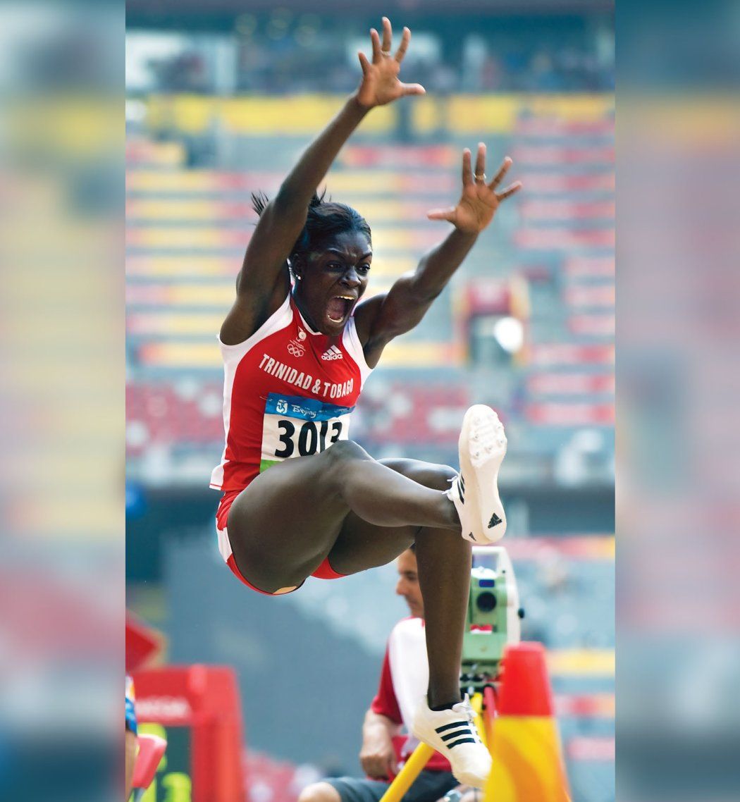 Photo of Rhonda Watkins flying through the air when competing in a long jump.