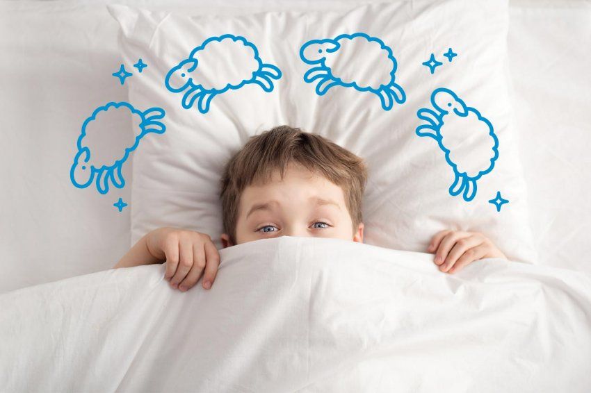 Photo of a child in a bed, peaking above the covers; illustration of sheep and stars circle around their head.