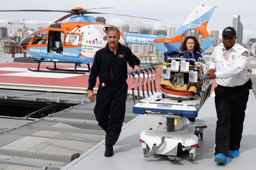 Trained paramedics pushing a gurney arrive from a helicopter at the new hospital.
