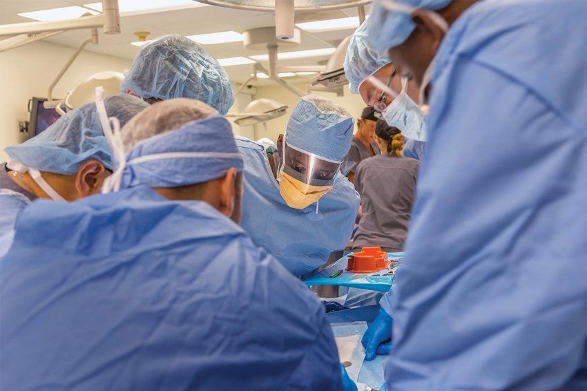 A group of surgeons overlooking a patient.