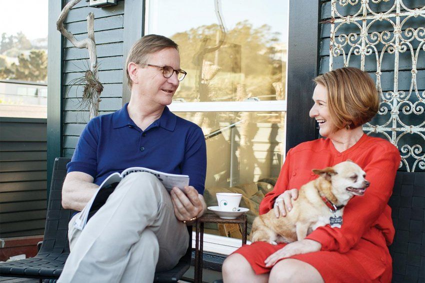 Sam and Jane Hawgood sit outside their home with their dog.