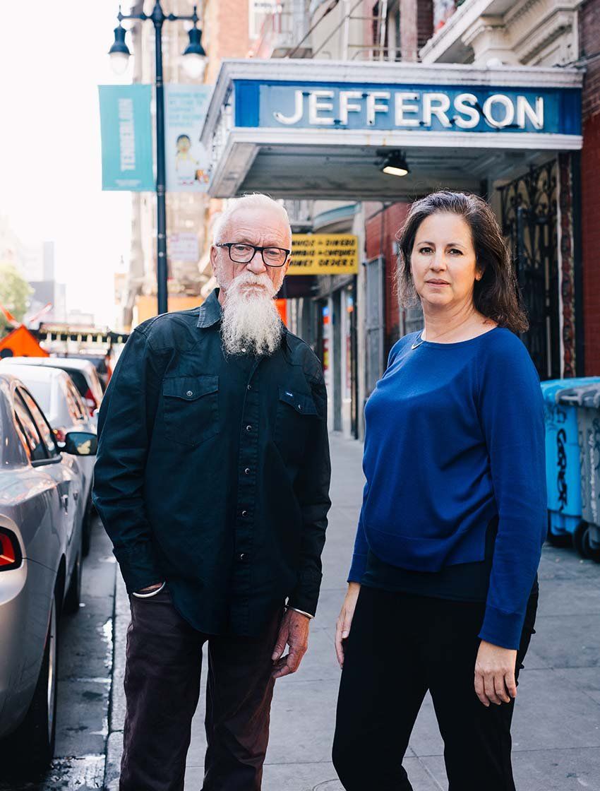 Daniel Hill and Carla Perissinotto stand together on the sidewalk in the Tenderloin district of San Francisco.