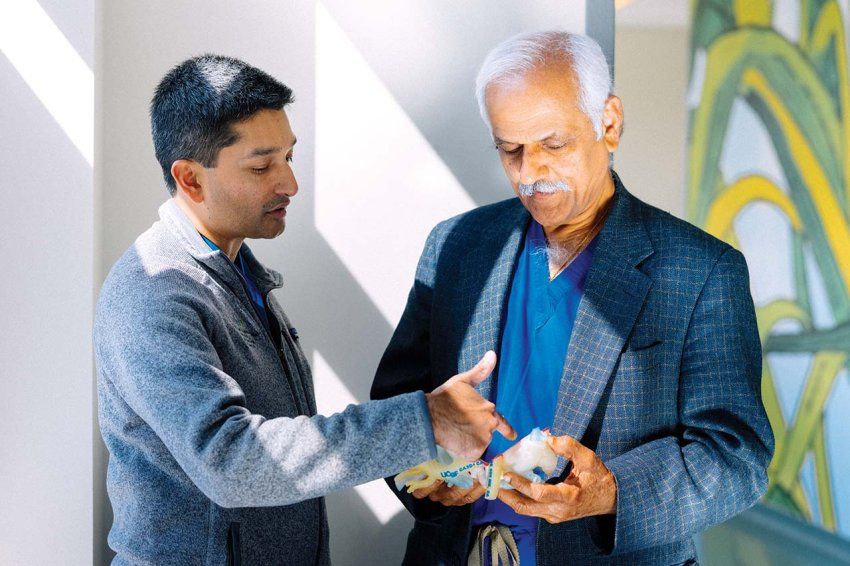 Dr. Anwar and Dr. Reddy discuss a 3D model of a heart.